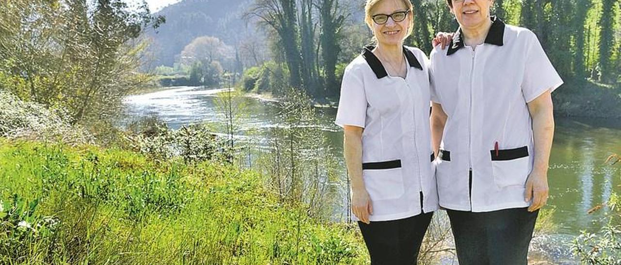 Por la izquierda, Josefina Pérez Díaz y Teresa Salas Valles, a la orilla del río Nalón a su paso por San Román de Candamo.