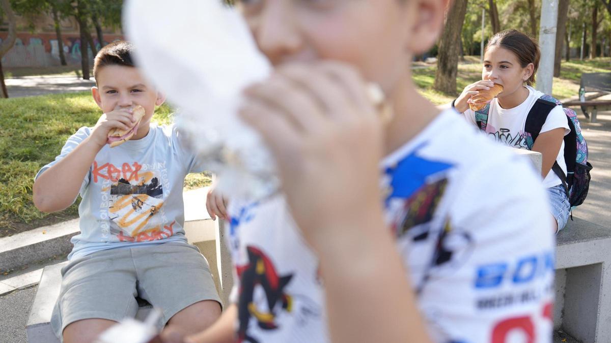 Unos niños toman su merienda al salir del colegio
