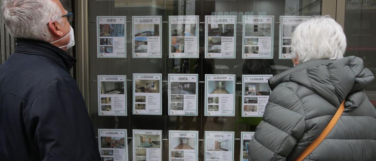 Dues persones miren preus de pisos en venda i en lloguer en una fotografia d’arxiu. | RICARD CUGAT