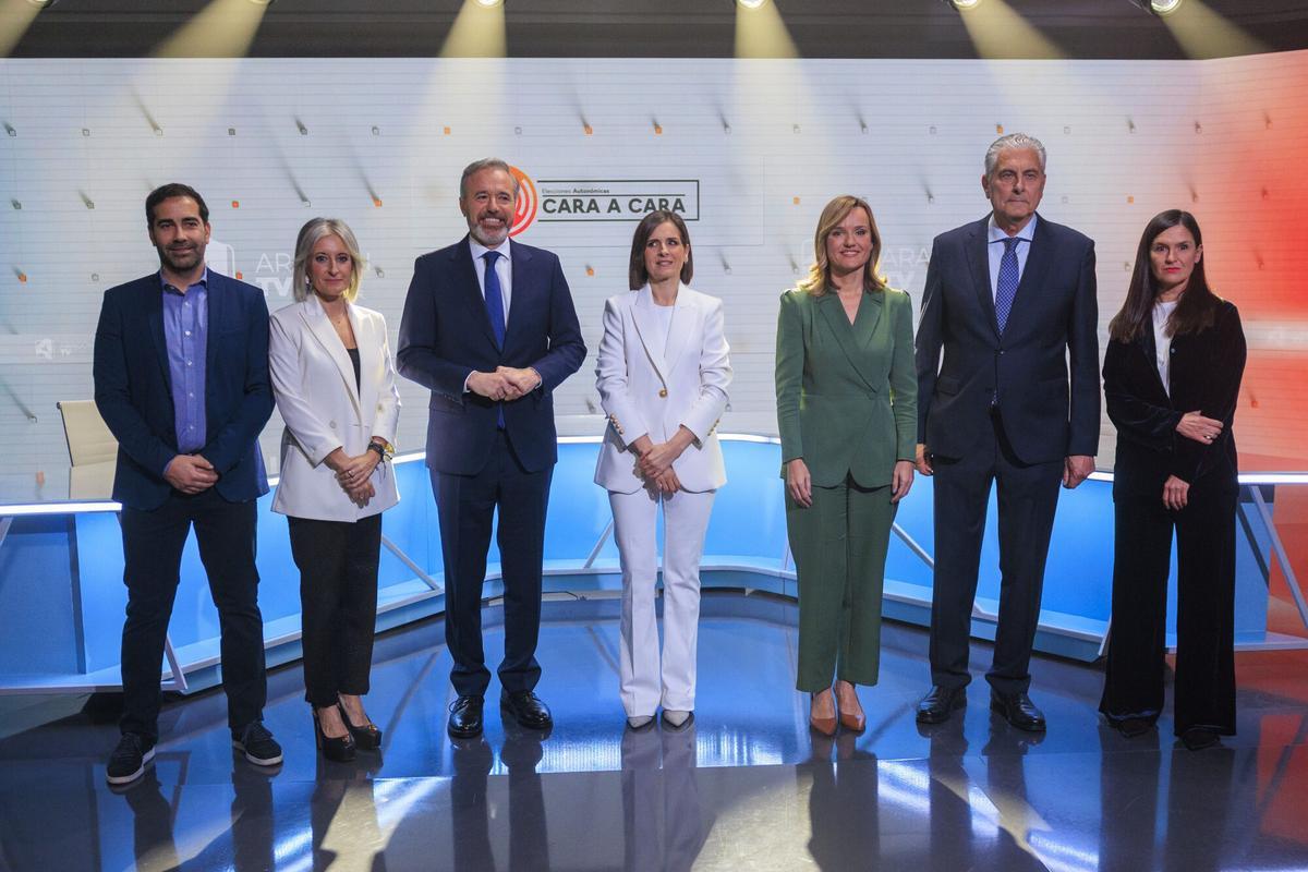 El candidato a la presidencia de Aragón por el PP, Jorge Azcón (3i) y la candidata del PSOE, Pilar Alegría (3d) posan con responsables de la Corporación Aragonesa de Radio y Televisión (CARTV) en el plató de Aragón TV antes de comenzar el debate cara a cara este lunes, en Zaragoza. EFE/ Javier Cebollada