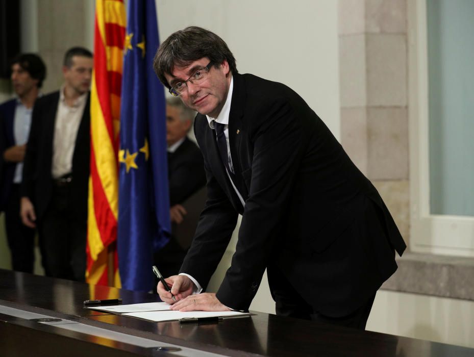 Catalan President Carles Puigdemont signs a ...