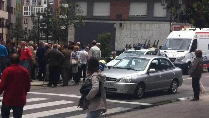 Numerosos curiosos presencian la intervención de los sanitarios en plena calle.