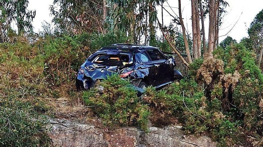 El vehículo accidentado, al borde del talud de la carretera.