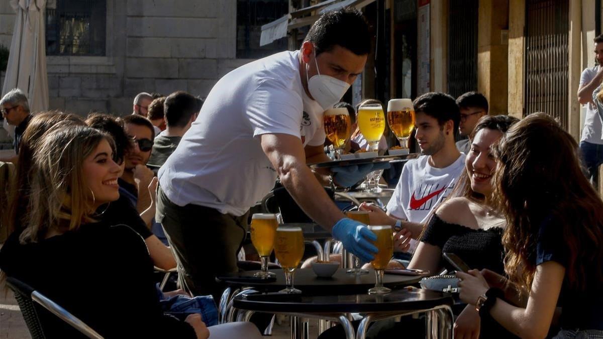 Un camarero sirve a sus clientes en un bar de la plaça de la Font de Tarragona