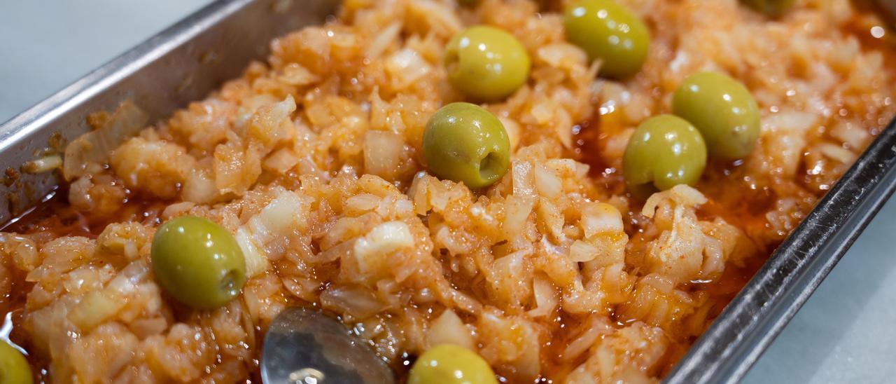 Preparativo con bacalao, cebolla y pimentón, con versión aceitunas verdes, en cafetería Tazzas.