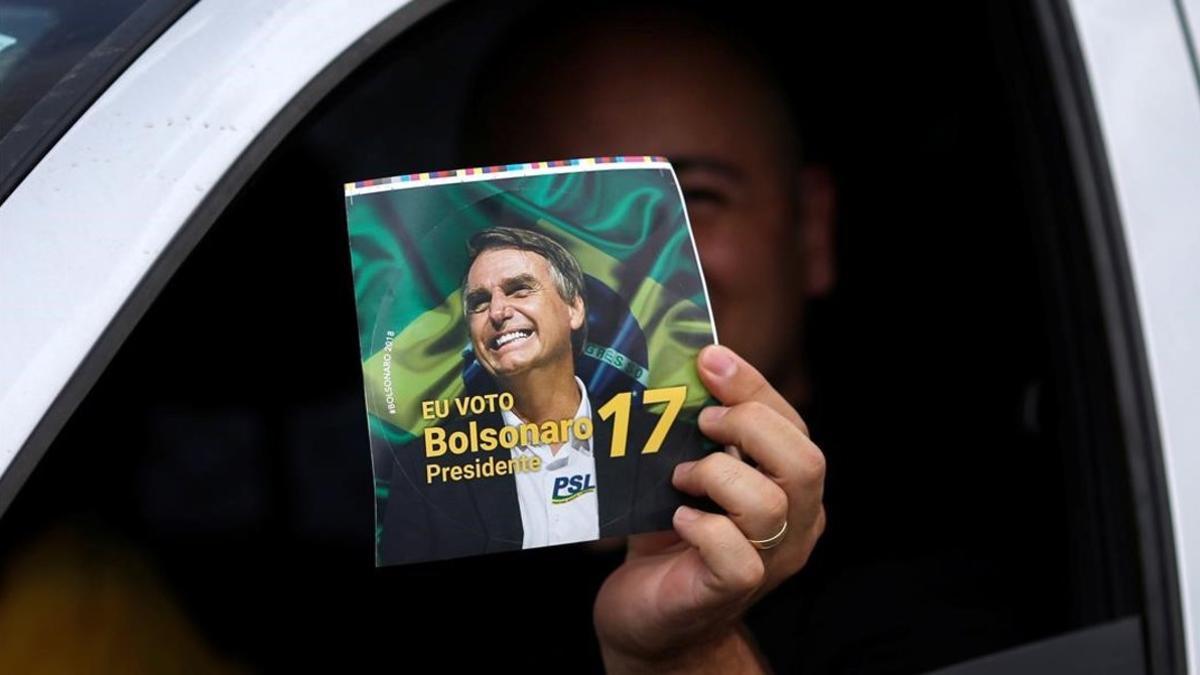 Un seguidor de Bolsonaro muestra la foto del dirigente.