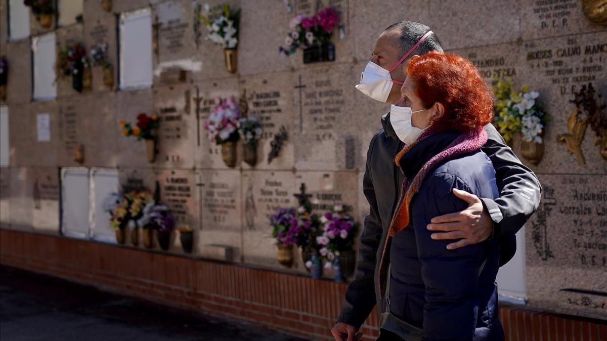 Unos familiares asisten al entierro de una víctima del covid-19.