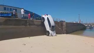 Un coche aparcado en la lonja de Bueu se precipita sobre la playa