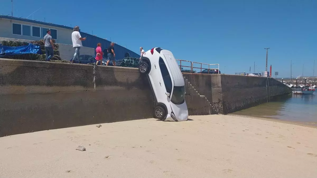 Un coche aparcado en la lonja de Bueu se precipita sobre la playa
