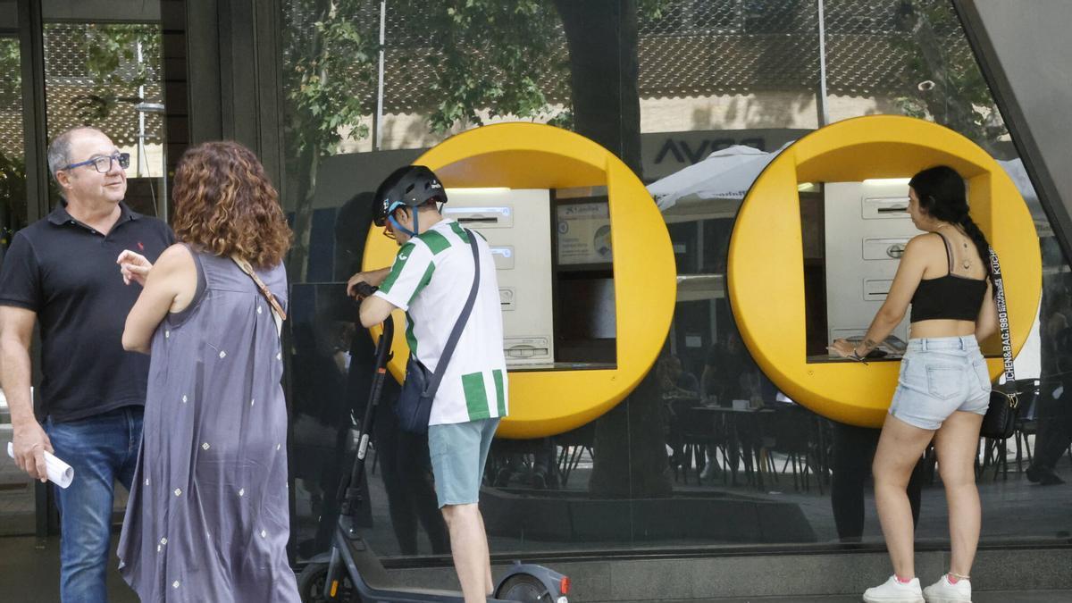 Clientes utilizan los cajeros de una entidad financiera en Córdoba.