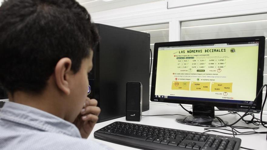 Un niño trabaja con un ordenador en clase