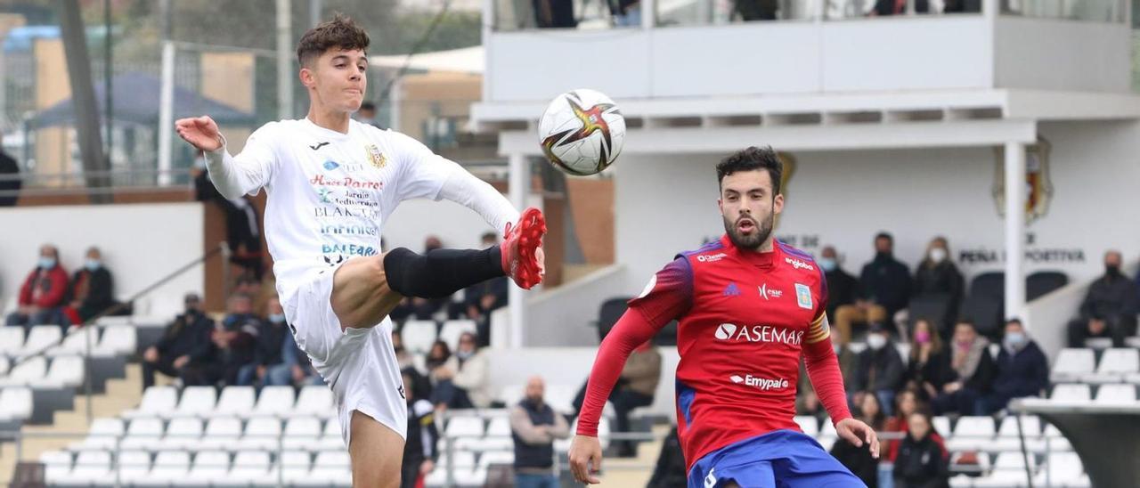 El joven futbolista Arnau Ortiz pica la pelota con clase, en una acción de ataque de la Peña Deportiva frente al Tarazona.  | JUAN A. RIERA