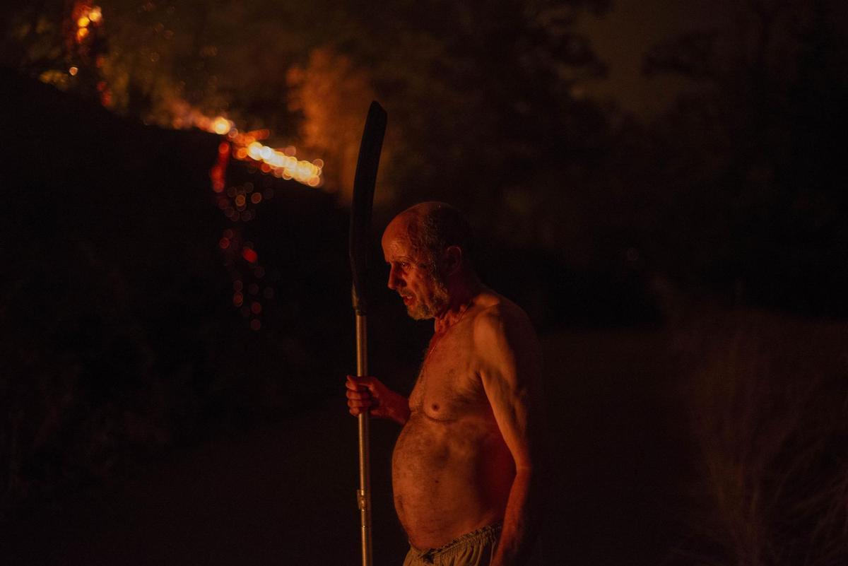 O BARCO DE VALDEORRAS (OURENSE), 18/07/2022.- La extinción de los incendios forestales declarados en Galicia, en esta ola de calor de julio, sigue dificultada por las condiciones climatológicas adversas, por lo que son varios los fuegos todavía activos y que afectan sobre todo a las provincias de Ourense y Lugo.En la imagen, un hombre observa el fuego del incendio forestal de O Barco de Valdeorras. El fuego se inició en el municipio de Carballeda de Valdeorras pero se ha propagado hasta afectar al municipio de O Barco de Valdeorras tras calcinar por el momento 2.400 hectáreas. EFE/ Brais Lorenzo