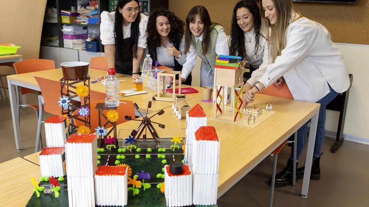 María Campos (a la derecha de la imagen), junto a sus compañeras y la maqueta de energías renovables, en el taller llevado a cabo en la Universidad Cardenal Herrera de Castellón. .