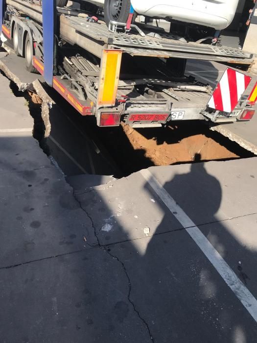 Un trailer cargado de coches del concesionario de Opel ocasionó un boquete en la calzada y tuvo que ser rescatado por una grúa de grandes dimensiones