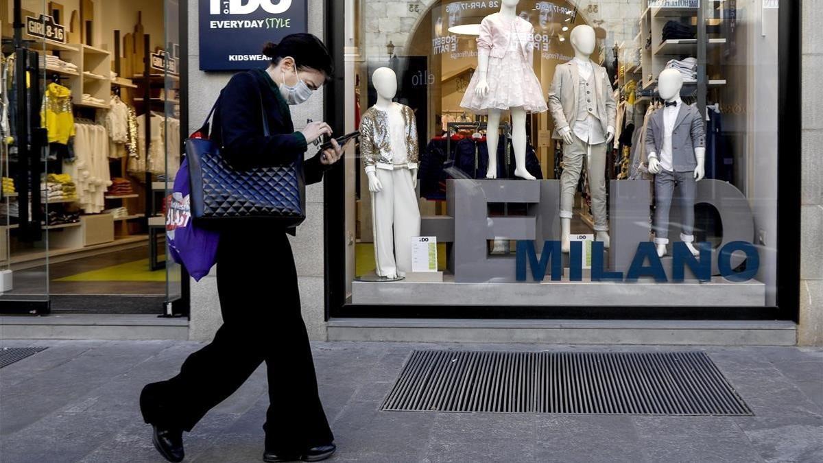 Una mujer pasa frente a una tienda de ropa para niños, este miércoles en Milán.