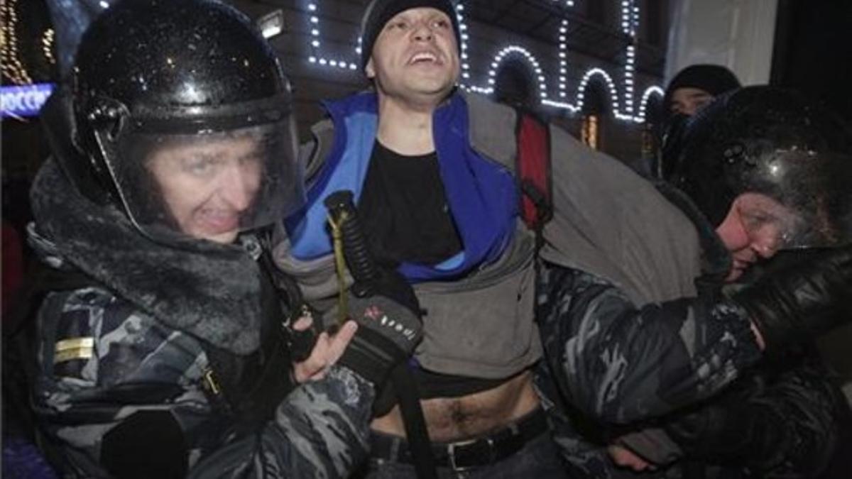 Unos policías antidisturbios arrestan a un joven que participaba en una concentración en contra de los resultados de las elecciones rusas.
