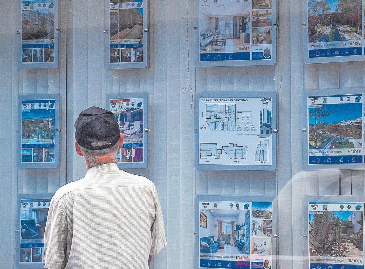 Un hombre mirando los carteles de una inmobiliaria.