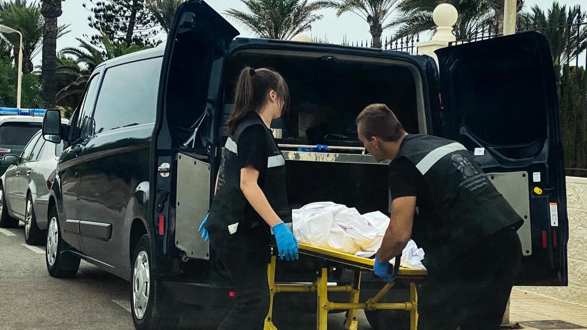 Dos trabajadores introducen en un furgón el cuerpo sin vida del niño hallado en La Manga.