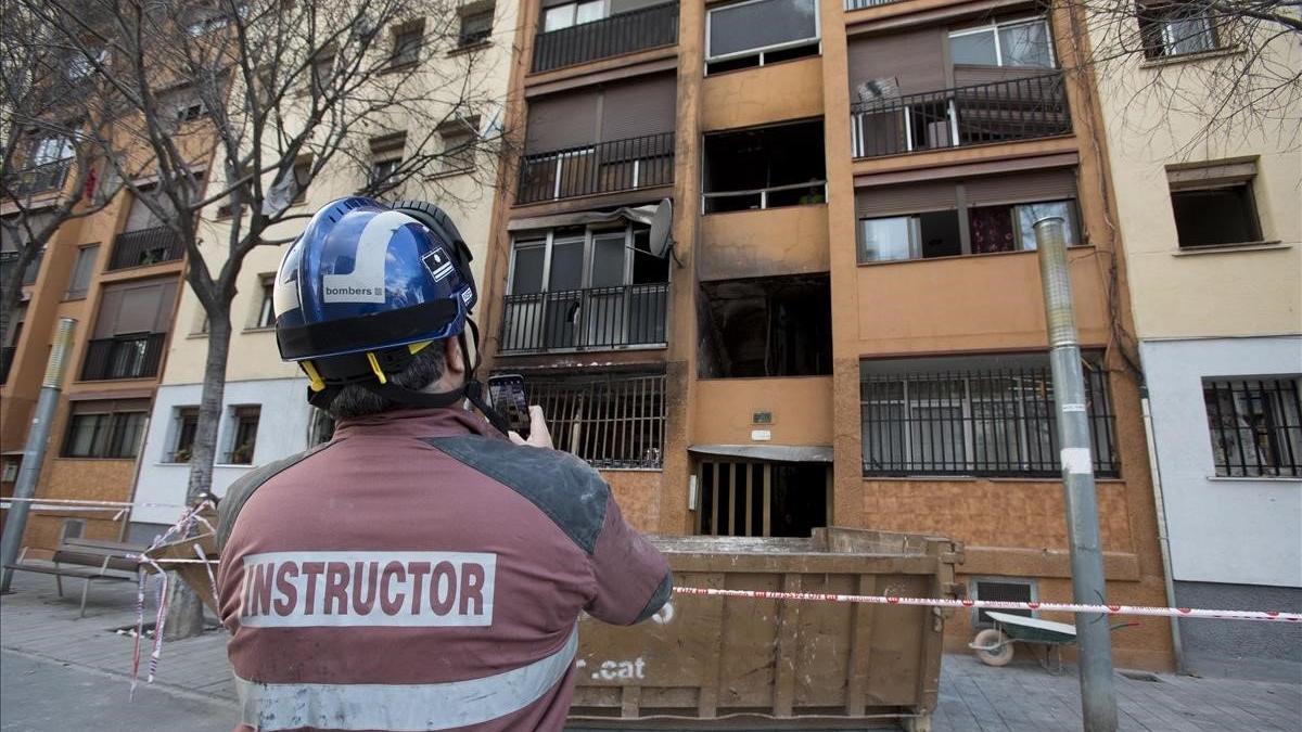 Un miembro del equipo de investigación de bomberos examinan el edificio del barrio de Sant Roc de Badalona donde el día 5 se produjo un incendio con tres personas muertas.