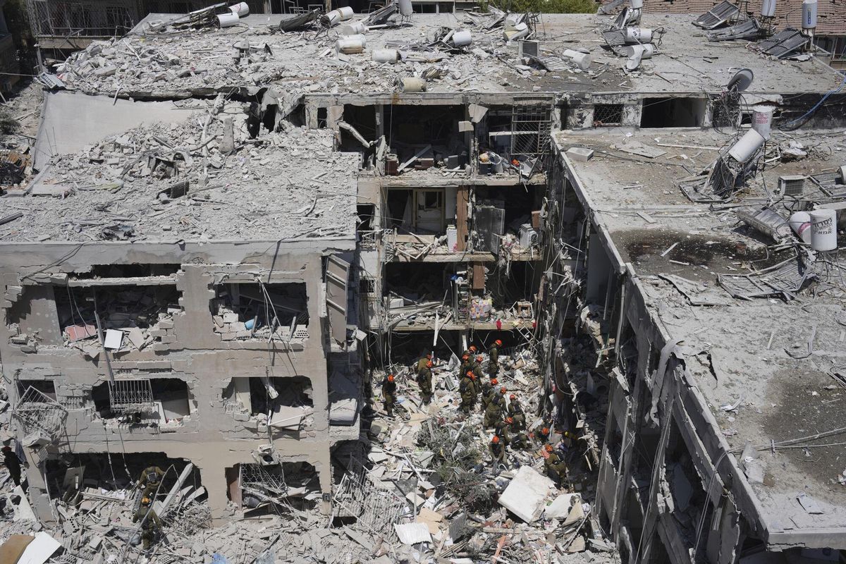 Israeli soldiers dig through rubble to search for survivors in a residential area hit by a missile fired from Iran, in Bat Yam, central Israel, Sunday, June 15, 2025. (AP Photo/Ariel Schalit)