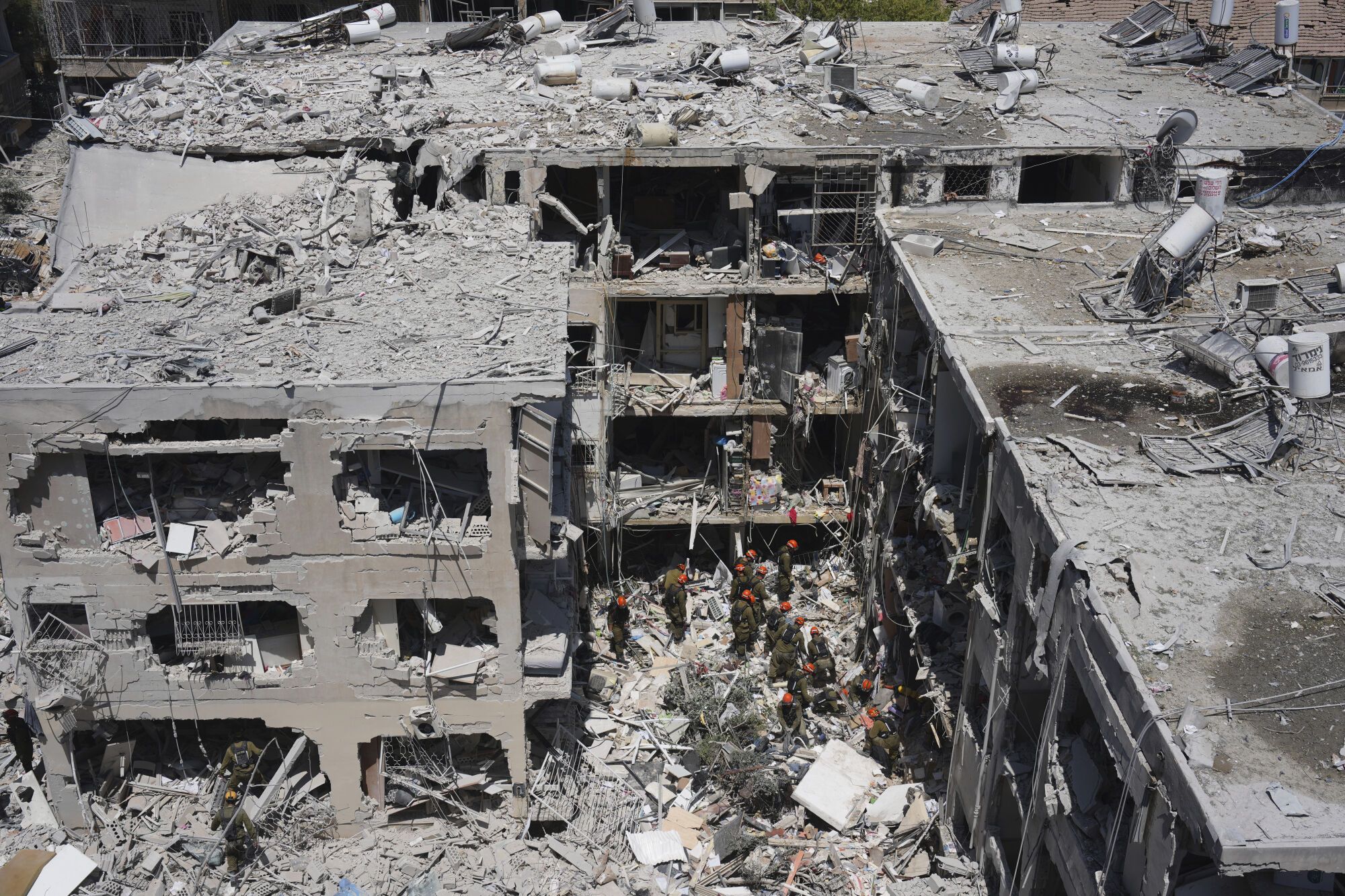 Israeli soldiers dig through rubble to search for survivors in a residential area hit by a missile fired from Iran, in Bat Yam, central Israel, Sunday, June 15, 2025. (AP Photo/Ariel Schalit)
