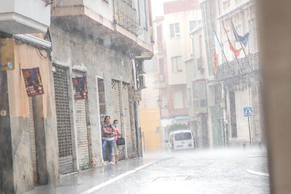 Un buen chaparrón ha sorprendido a primera hora a los peatones en el centro histórico de Orihuela. Las lluvias y tormentas se prolongarán esta tarde con posibilidad de granizo.