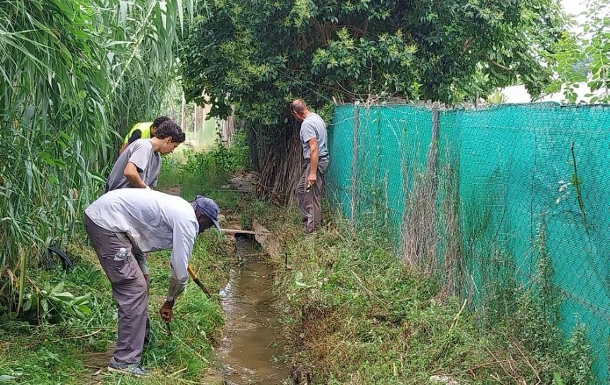 Treballs de neteja de la xarxa de recs a les hortes de Salt en una jornada de treball comunitari oberta a la població
