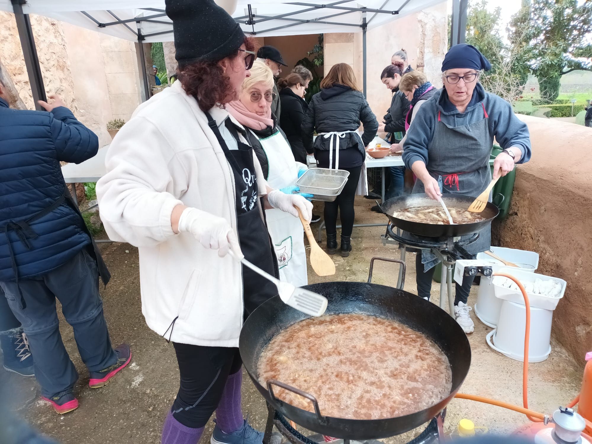 Los miembros de la Escola de Ball de Bunyola preparando la comida de la fiesta del Quarteró