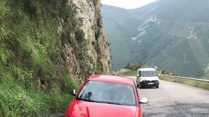 Coches en la carretera de Boinás, llena de baches.