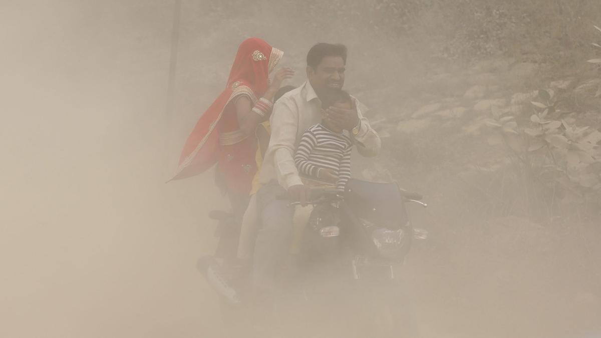 Una fotografía de una familia en India rodeada de polución
