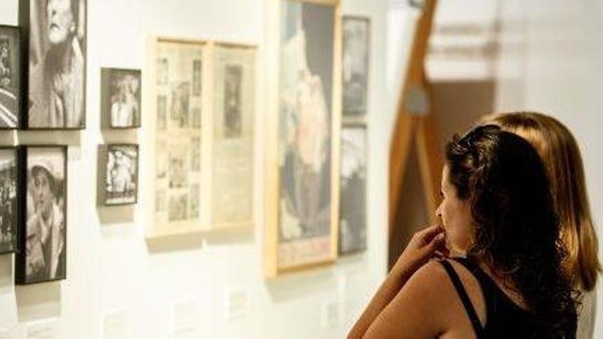 Dos mujeres observan varias de las fotografías que se exhiben en la exposición.