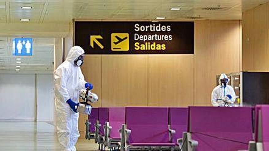 Dos miembros del Ejército desinfectan la terminal del aeropuerto de Ibiza.