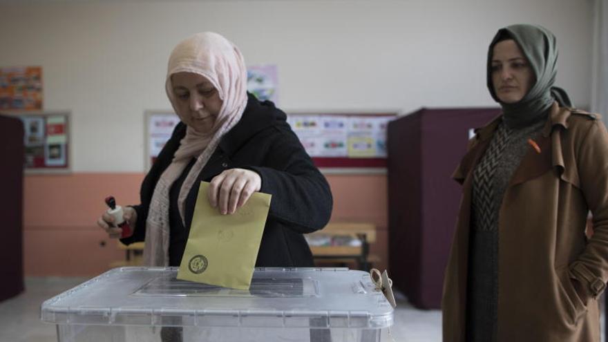 Una mujer introduce su voto en una urna en Estambul.