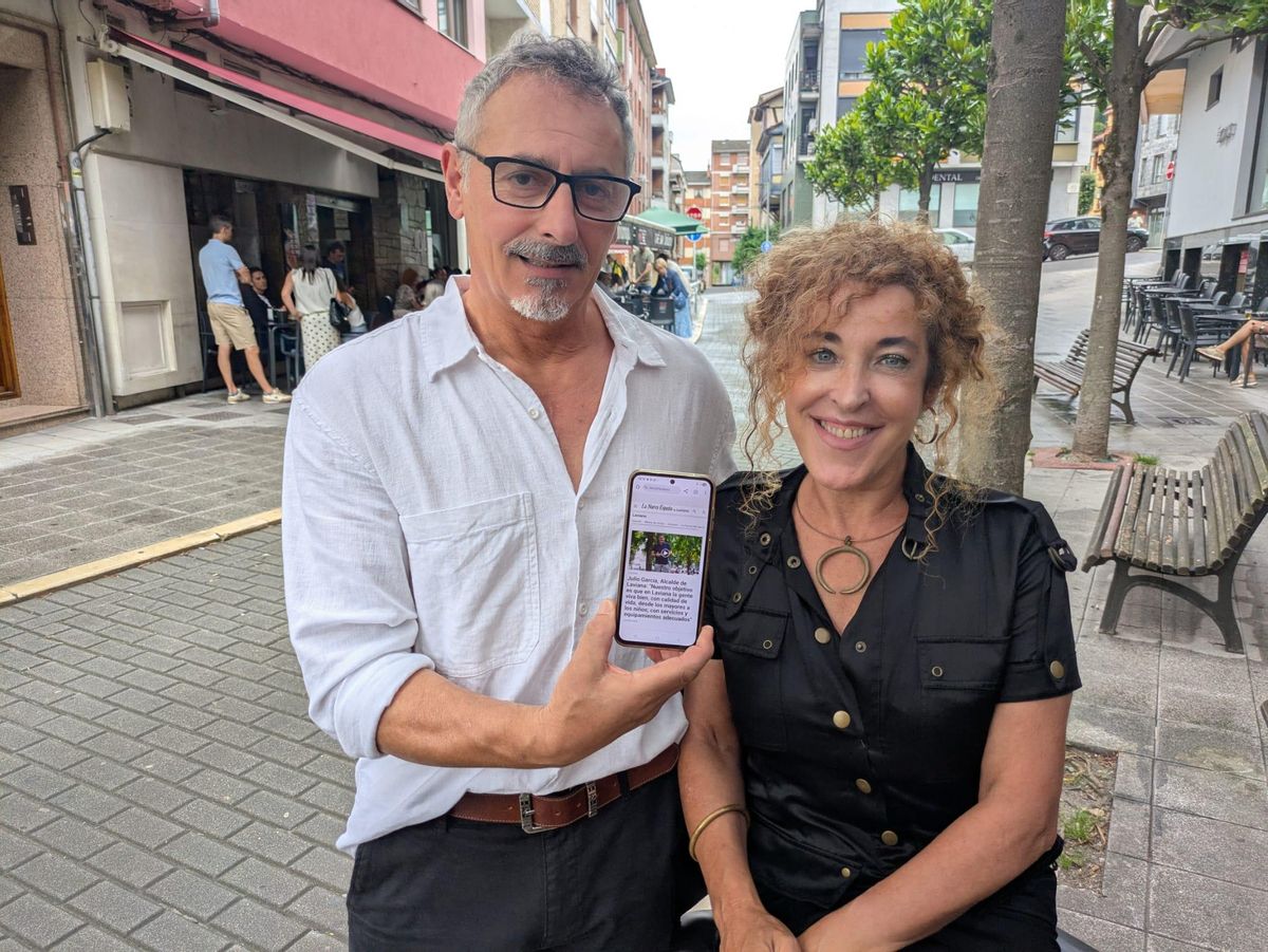 Natividad Cortázar y Óliver Barbón, mostrando su teléfono con información de Laviana