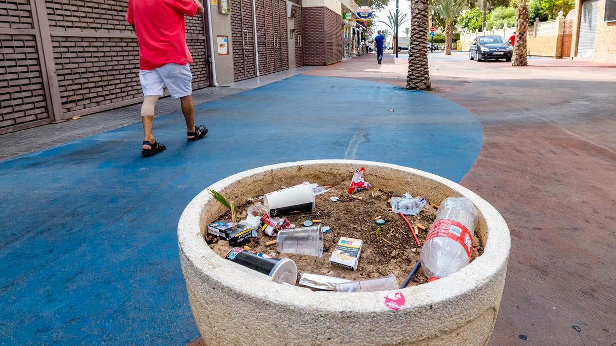 Un macetero en la calle Mallorca de Benidorm, el &quot;corazón&quot; de la zona del turismo inglés, lleno de residuos.