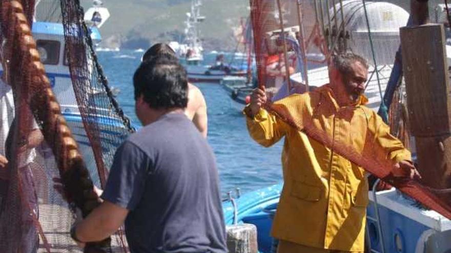 Un grupo de marineros prepara las redes en un puerto gallego para salir a faenar. / víctor echave