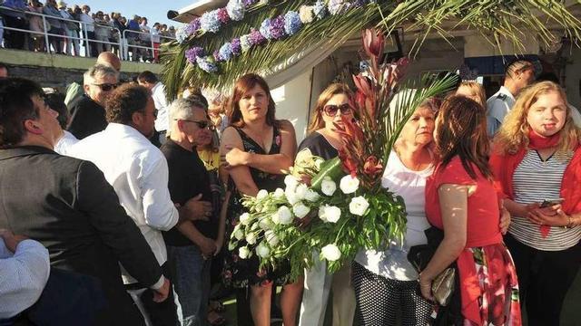 La alcaldesa de Cambados, Fátima Abal, besa en el bateeiro "Muxes"a María del Carmen García, la vecina que leyó el poema. // Iñaki Abella