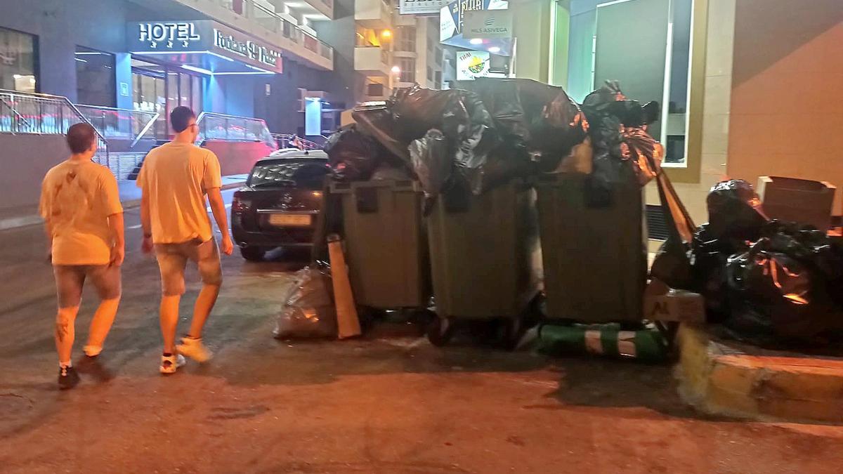 Acumulación de residuos a primera hora de la noche en una isla de contenedores del centro de Torrevieja