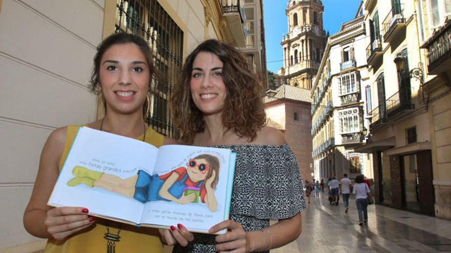 Elena López y María Díaz, autoras de El Viaje de Alma, mostrando unas páginas de su libro.