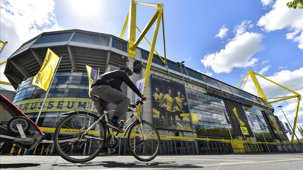 Un ciclista pasa por delante del estadio del Borussia Dortmund, que volerá a acoger este fin de semana la Bundesliga