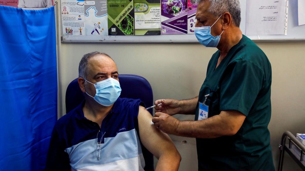 A man receives the AstraZeneca vaccine against the coronavirus disease (COVID-19) in a government dispensary, in Baghdad