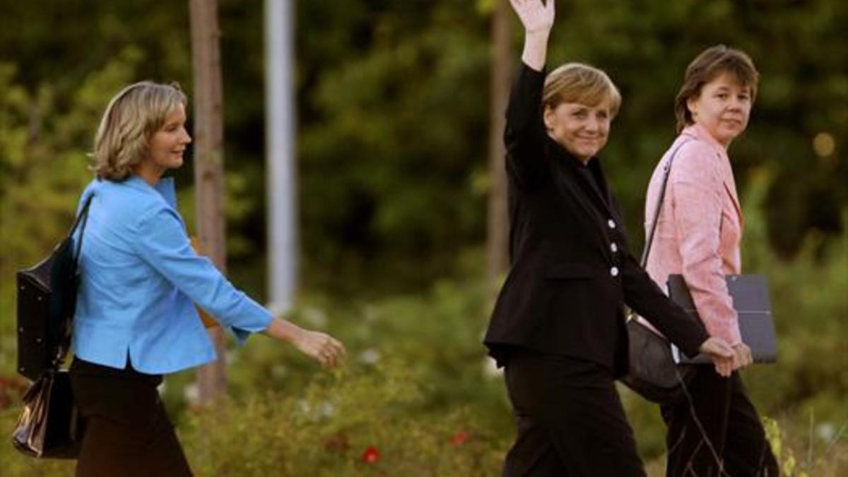 el trio lalala.  Angela Merkel, custodiada por Beate Baumann (derecha) y Eva Christiansen,  a la llegada de la cancillera a un estudio de TV de Berlín.