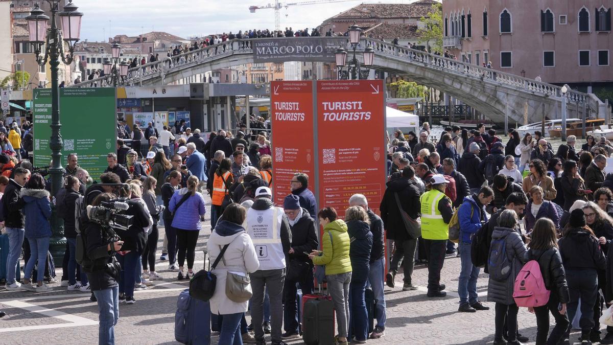 Turistas hace cola para validar el código de acceso a Venecia a las afueras de la principal estación de tren.