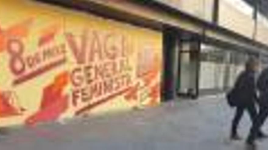Un mural anunciant la vaga del 8 de març en una plaça de Girona