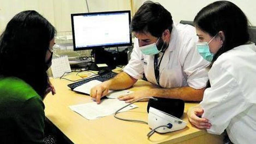 Els doctors Manel Mendoza i Alba Ferràs amb una pacient, consultant informació