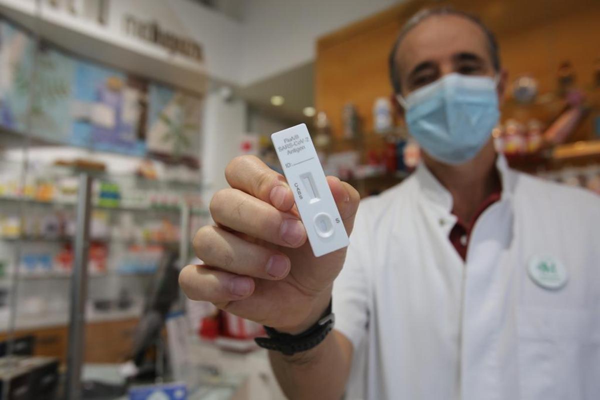 Un farmacéutico de Alicante muestra el nuevo test que permite detectar covid y/o gripe