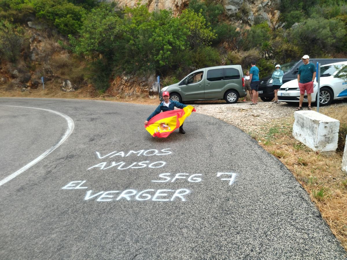 Un aficionado de El Verger muestra el mensaje de apoyo a Juan Ayuso escrito en una de las rampas del puerto de la Vall d'Ebo