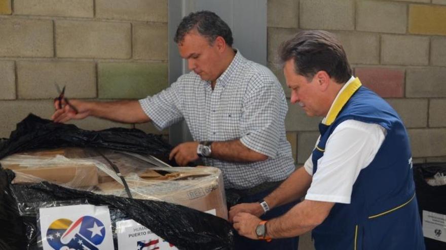 Dos hombres desembalan un paquete de ayuda.