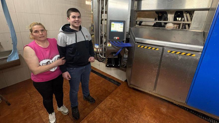Loli Cano, con su hijo Iker Álvarez, al lado del robot de ordeño. | D. ÁLVAREZ